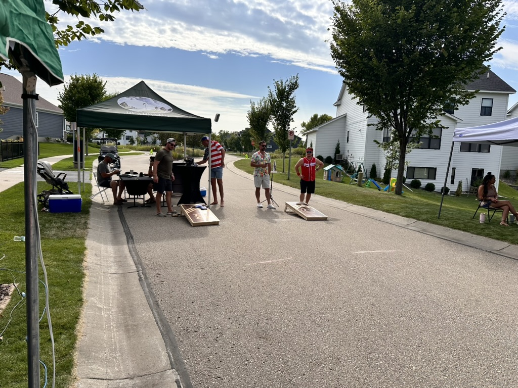 Cornhole teams competing in the middle of the neighborhood street