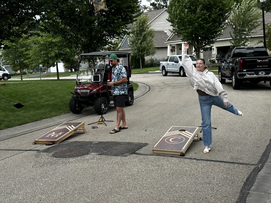 A cornhole player releasing a bag during the neighborhood competition