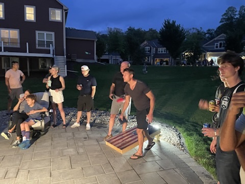 Spectators gathered around the patio court as the Corn Hole Championship moves into the night