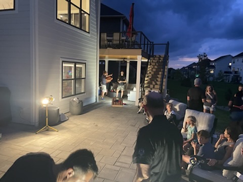 Championship cornhole played on the patio beneath the lights after dark